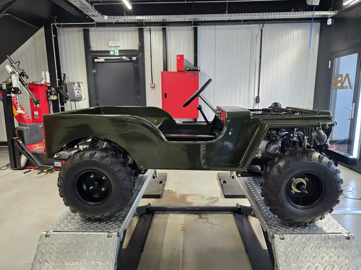 Donkergroene custom mini jeep buggy in de werkplaats